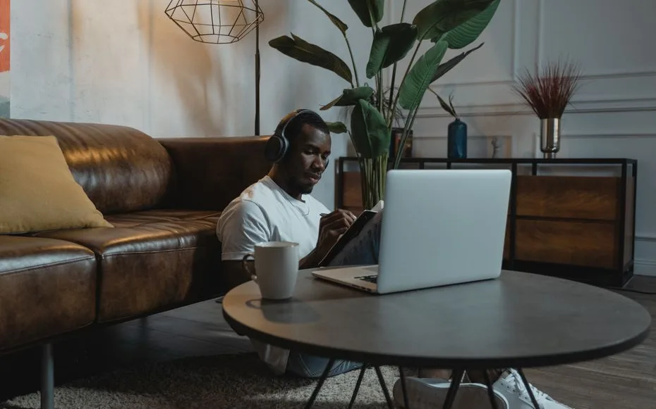 Personne installée dans un salon calme avec un ordinateur portable et un casque